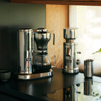 Aarke Coffee brewing equipment on a kitchen counter with a window in the background