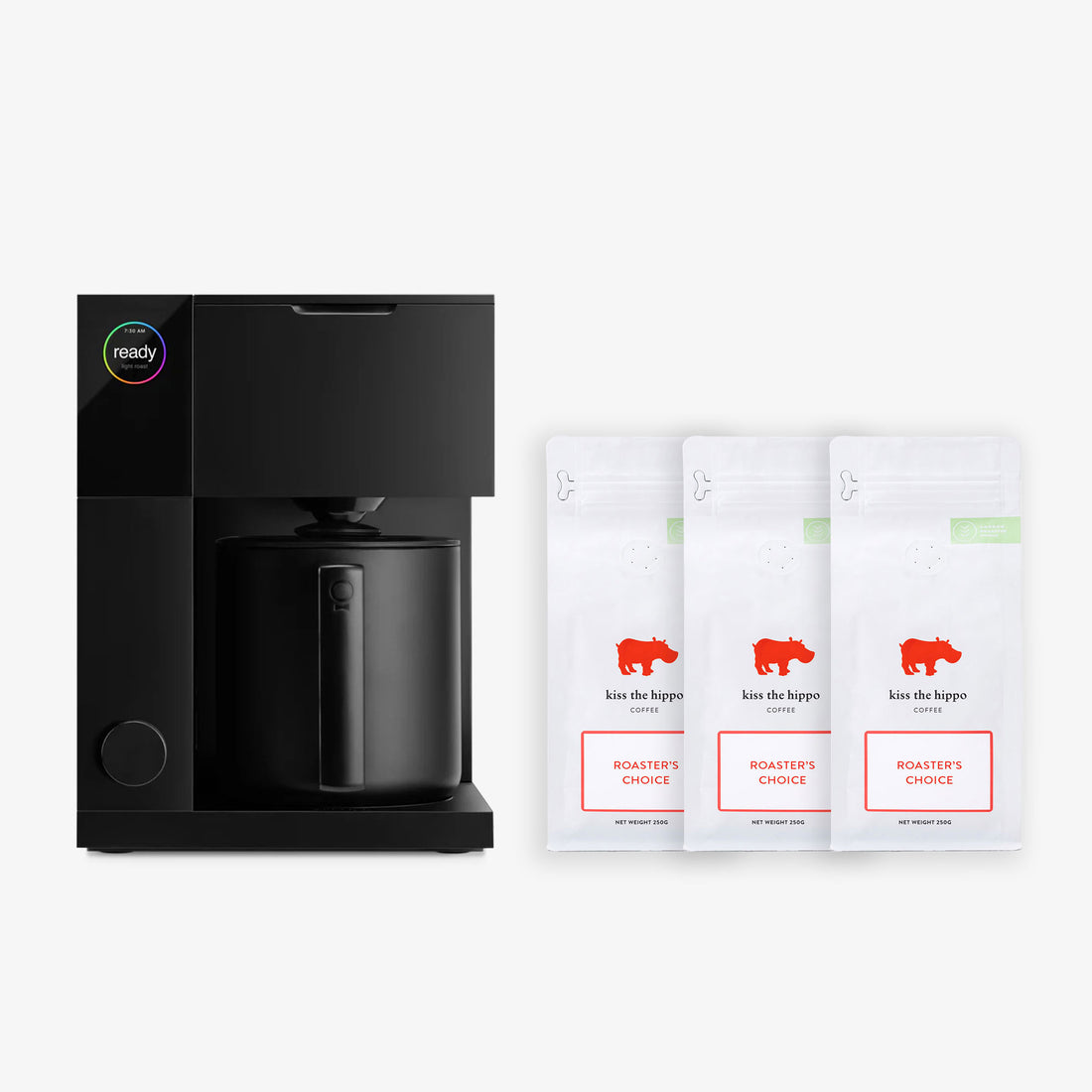 Fellow Aiden coffee maker with a sleek design, alongside three bags of coffee, on a white background.