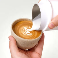 Pouring microfoam milk from a Subminimal NanoFoamer onto espresso
