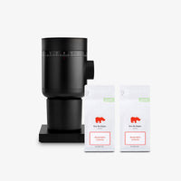 Fellow Opus 2 grinder in matte black with two Kiss the Hippo Roaster's Choice coffee bags
