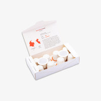 An open white cardboard box containing kiss the hippo coffee pods, photographed on a clean white background. The inside lid has printed text and an orange map graphic.