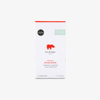 A package of Kiss the Hippo Coffee Organic House Blend capsules, featuring a white box with a red hippo logo and red text, set against a light grey background.