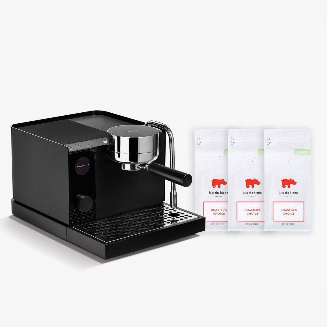 A black semi-automatic espresso machine with a chrome portafilter, shown next to three white coffee bean bags labeled 'koe de hopper' on a clean white background.
