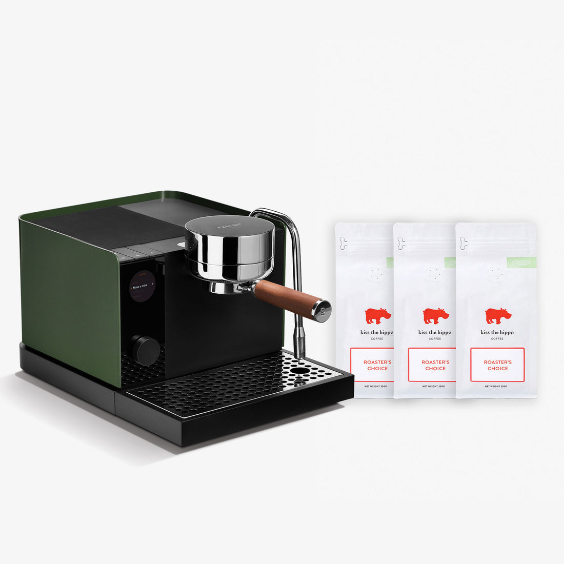 A sleek espresso machine in dark green and black with a chrome portafilter and wooden handle, shown alongside three white coffee bean bags labeled 'Koe Die Hopper Roasted Coffee' on a clean white background.
