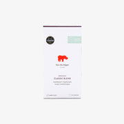 A white rectangular box of 'kiss the hippo' Organic Classic Blend coffee capsules, featuring a red hippo logo and black text, set against a solid off-white background.