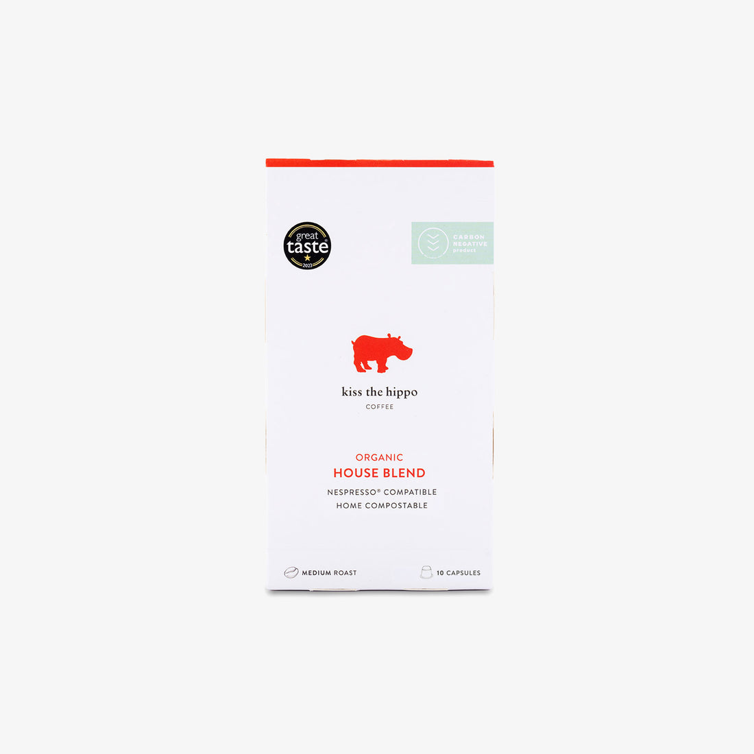 A package of Kiss the Hippo Coffee Organic House Blend capsules, featuring a white box with a red hippo logo and red text, set against a light grey background.