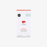 A package of Kiss the Hippo Coffee Organic House Blend capsules, featuring a white box with a red hippo logo and red text, set against a light grey background.
